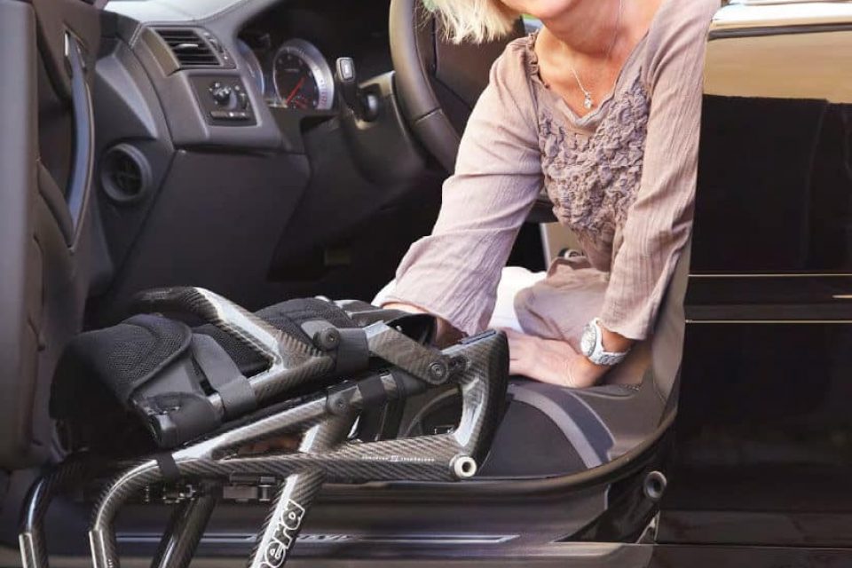 Frau-steigt-vom-Auto-aus-in-einen-panthera-Rollstuhl-ein-ultraleichter-Rollstuhl-827x1024